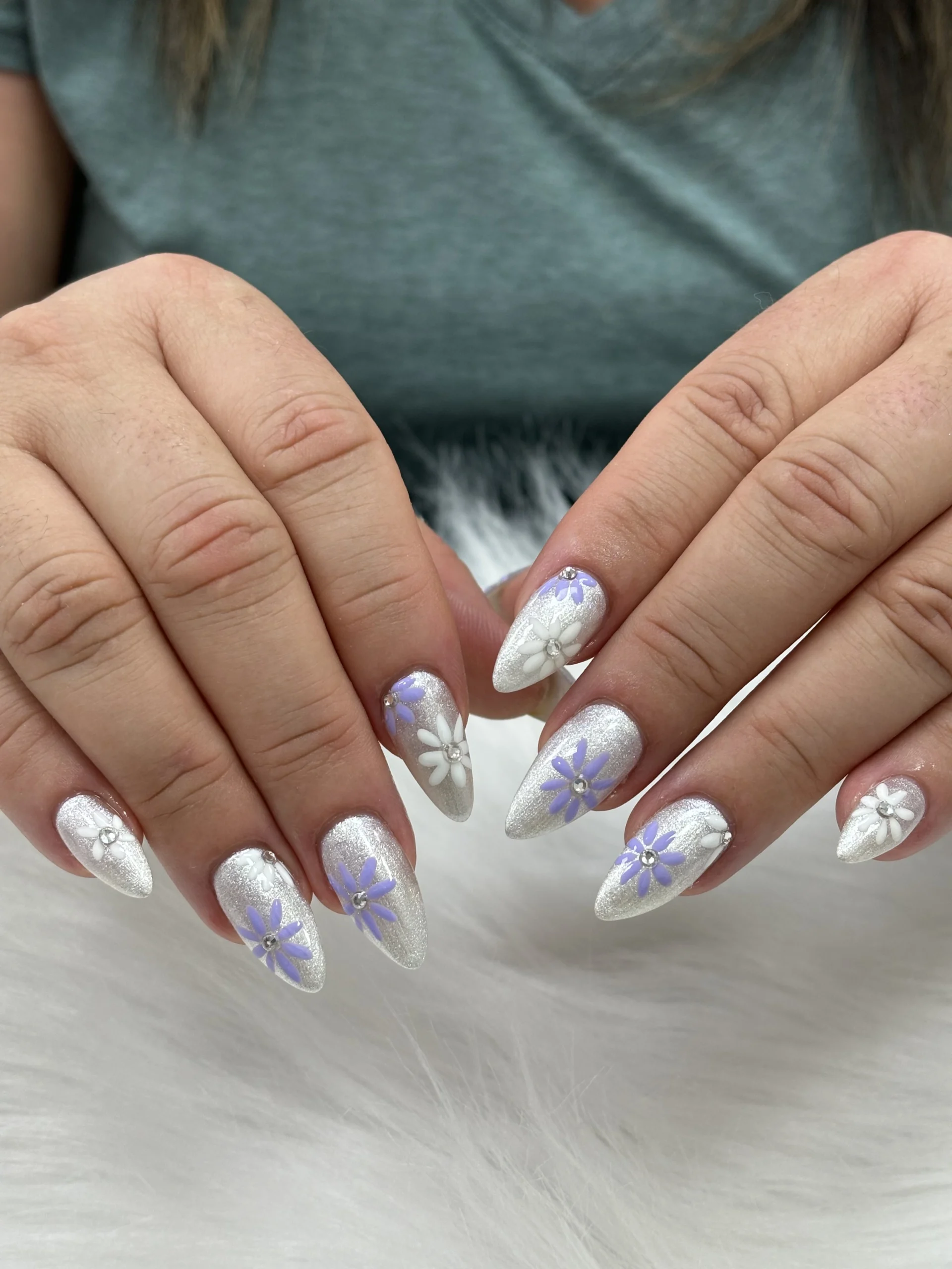 Pink French tip nails resting on a white fur backdrop